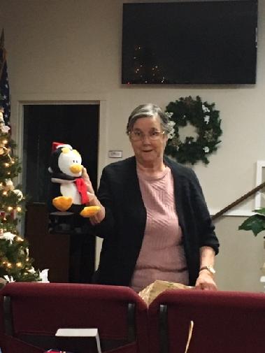 Senior Woman Holding Christmas Penguin Teddy